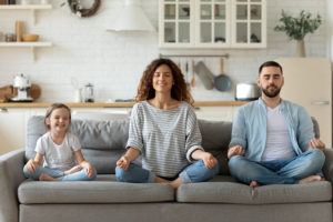 Familie sitter i sofa og mediterer