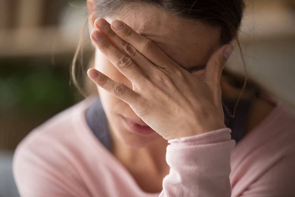 PTSD, fortvilet dame holer hendene foran ansiktet