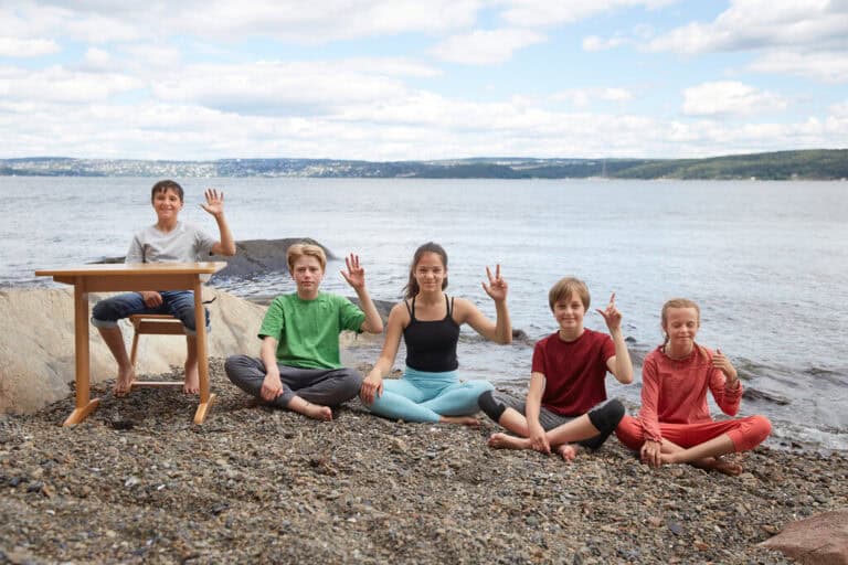 Barn gjør yoga på stranden - harachakra